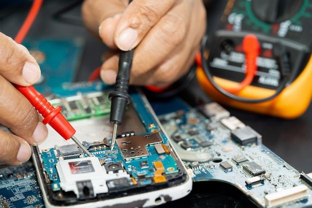 Technician repairing inside of mobile phone by soldering iron integrated circuit the concept of data hardware technology | Premium Photo