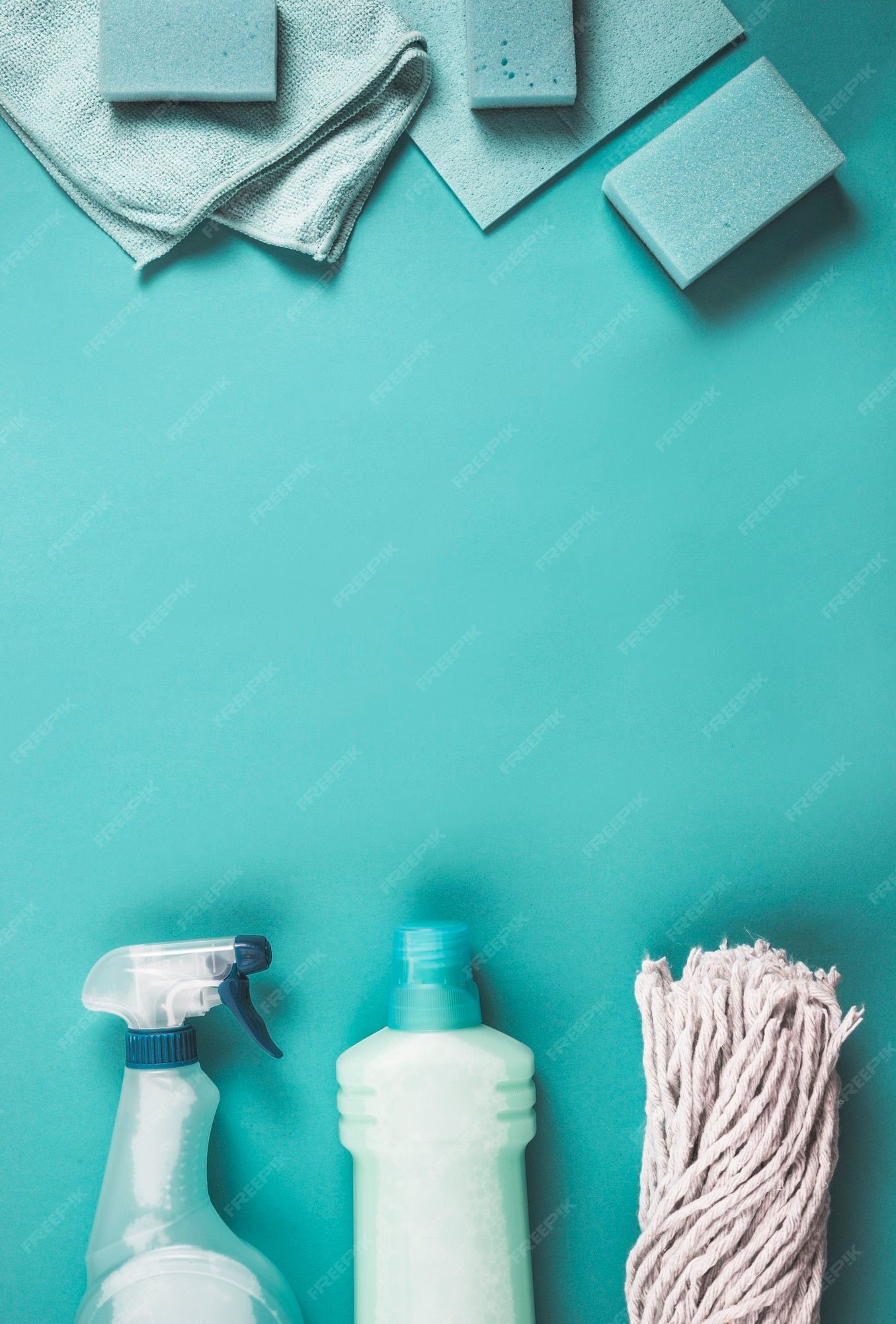 Elevated view of plastic bottles, mop head, sponge and napkin on turquoise backdrop | Premium Photo