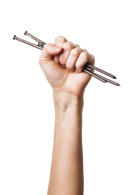 Construction nails in a female hand isolated on white background | Premium Photo